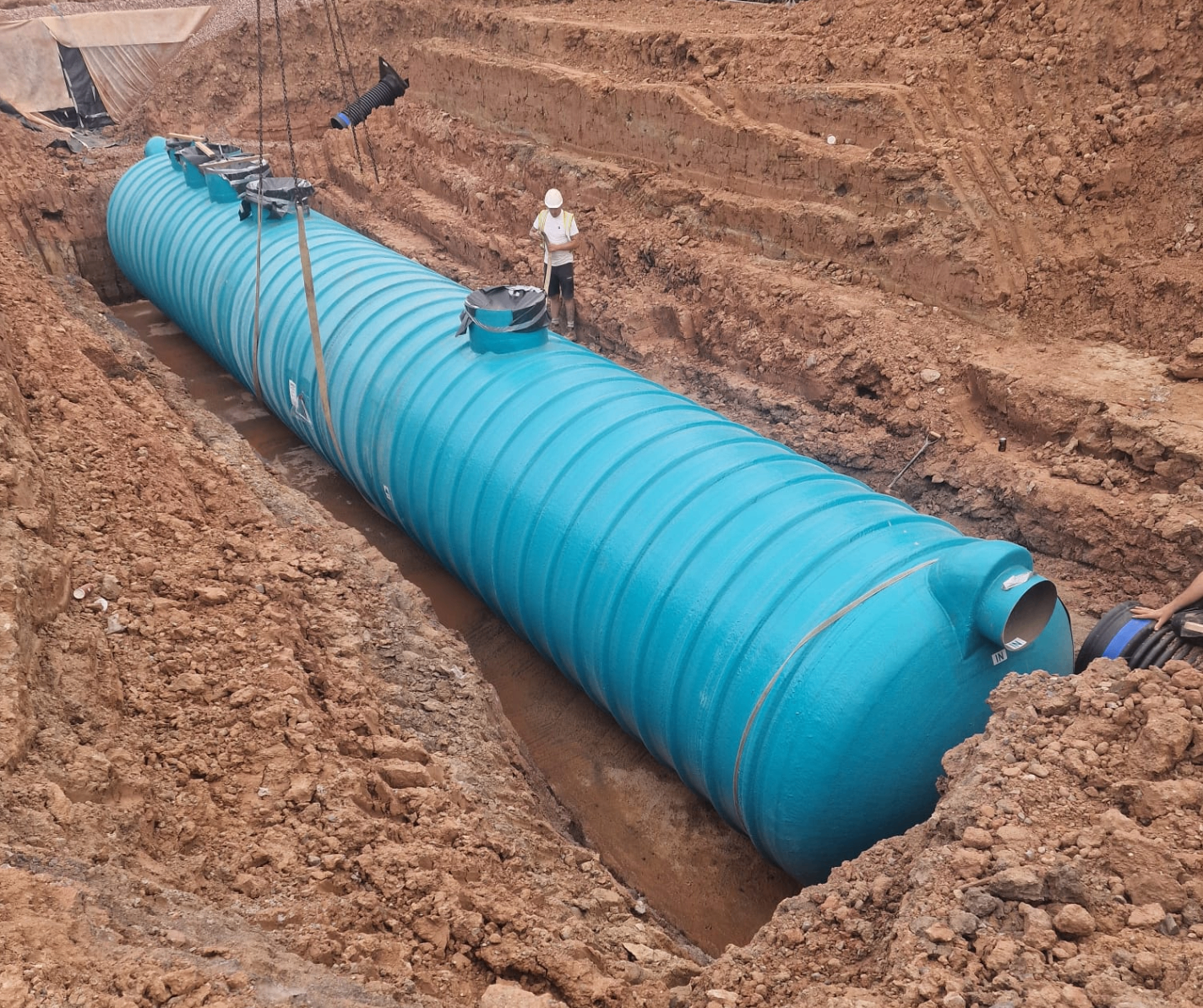 Large blue interceptor tank installation showing professional groundwork and civil engineering expertise